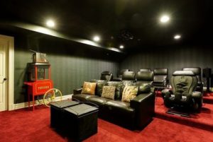 Home theater in shingle style home by DeMotte Architects