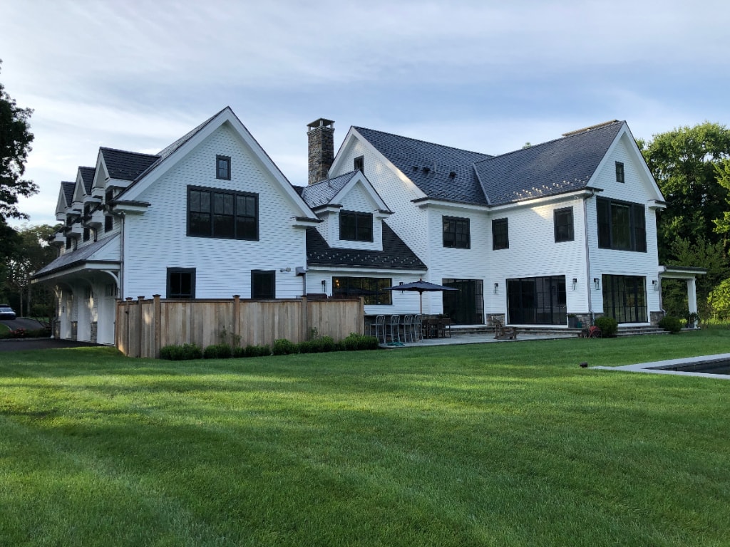 Connecticut home with large windows modern farmhouse design by DeMotte Architects