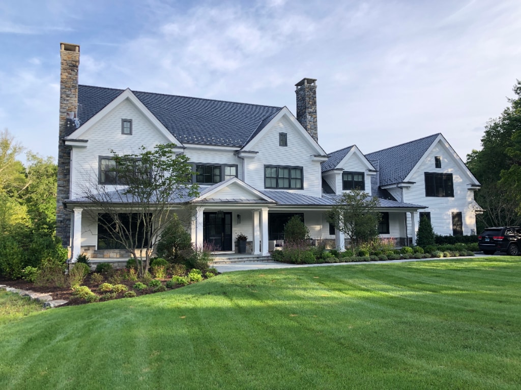 Contemporary farmhouse with large windows by DeMotte Architects